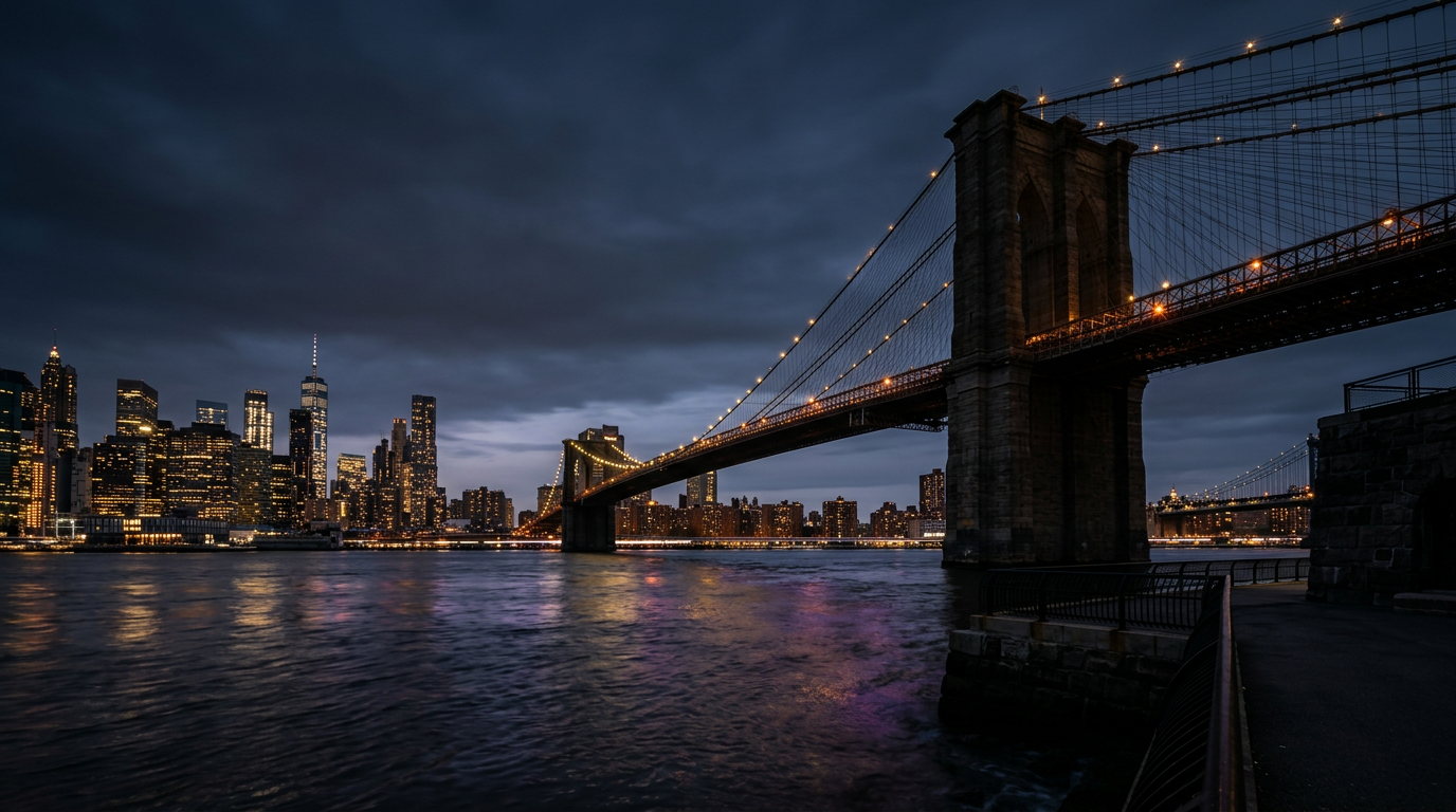 Brooklyn Bridge and Manhattan skyline at dusk, with deep sky and city lights.